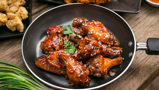 Sweet and spicy Korean fried chicken (yangnyeom) — glossy red gochujang-glazed crispy chicken wings sprinkled with sesame seeds and scallions