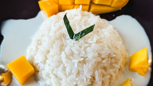 Thai mango sticky rice — a mound of coconut sticky rice with fresh ripe mango slices and coconut cream sauce